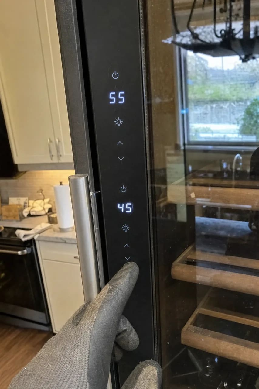Touch control panel on a wine column showing two zone temperatures in blue digits